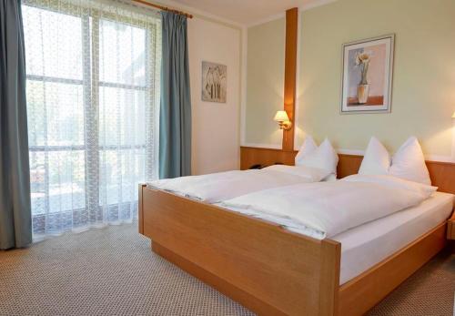 a bedroom with a large bed with a large window at Gästehaus Bauer am Golfplatz in Prien am Chiemsee
