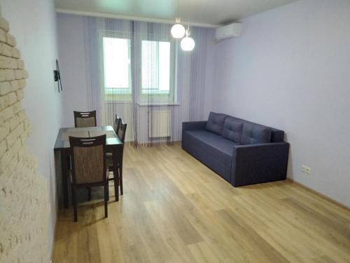 a living room with a blue couch and a table at Современная квартира в новом комплексе возле Днепра in Cherkasy