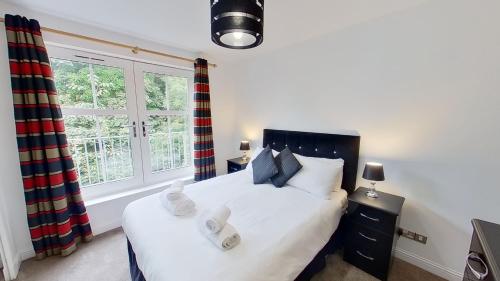 a bedroom with a bed and a window at Orange Apartments Rubislaw Mansions in Aberdeen