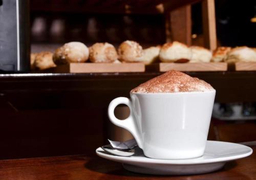 uma xícara de café em um prato sobre uma mesa em Browns Boutique Hotel em Lisboa