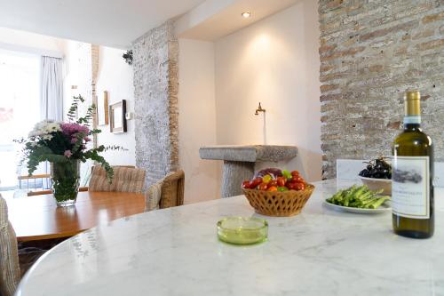 a bottle of wine sitting on a table with a bowl of vegetables at Frascati Country House in Grottaferrata