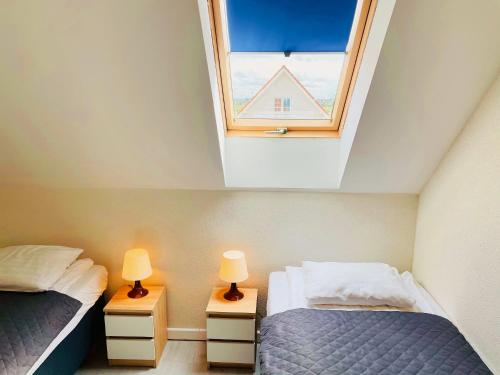 2 Betten in einem Zimmer mit Fenster in der Unterkunft Domki Summer Home Łeba in Łeba