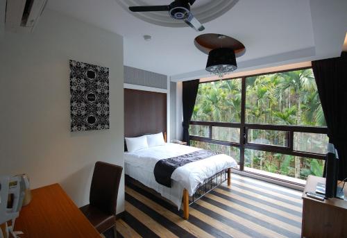 a bedroom with a bed and a large window at Full House Homestay in Yuchi