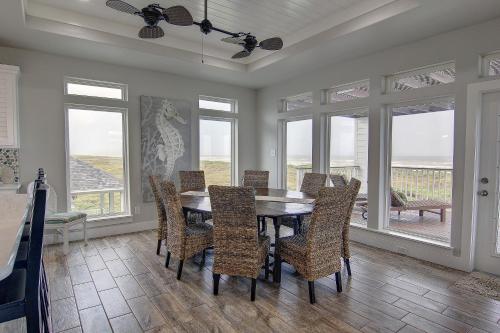 a dining room with a table and chairs and windows at The Pearl of Port A GW108 in Port Aransas