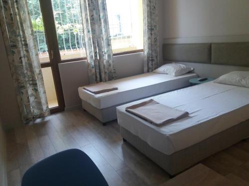 a hotel room with two beds and a window at Студио Булаир 1 in Burgas