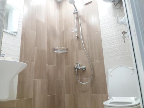 ein Bad mit einer Dusche, einem WC und einem Waschbecken in der Unterkunft Студио Булаир 1 in Burgas City