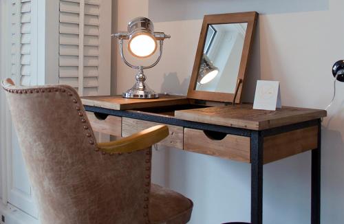 a desk with a mirror and a chair in a room at Weyotel in Weyhe