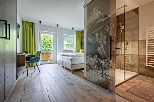 een badkamer met een douche en een slaapkamer met een bed bij Hotel Stern in Ehrwald