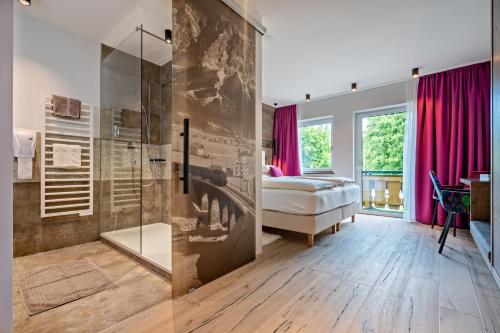 a bedroom with a bed and a glass shower at Hotel Stern in Ehrwald