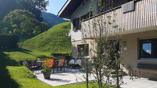 a house with a patio with chairs and a table at Ferienhus Klus 415 in Mellau