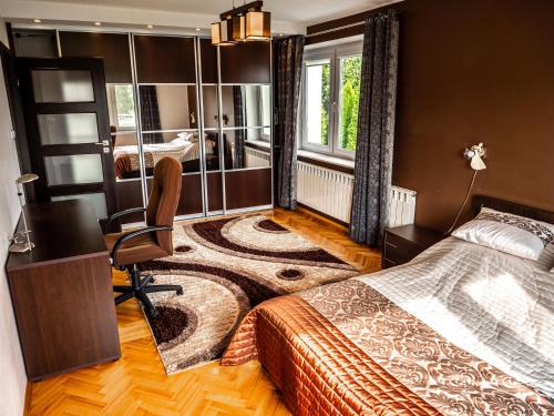 a bedroom with a bed and a desk and a chair at Podlaska Oaza - Dom całoroczny z sauną. in Pułazie Świerze