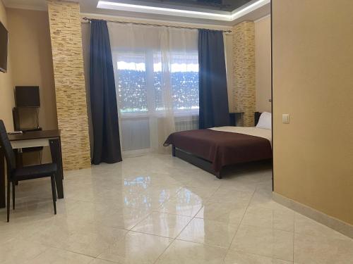 a bedroom with a bed and a desk and a window at Міні-готель "Кімната Комфорт" in Odesa