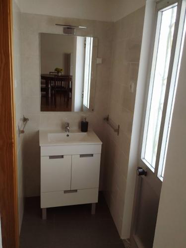 a bathroom with a white sink and a mirror at Casa da Eira in Bordeiro
