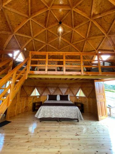 a bedroom with a bunk bed in a wooden house at Glamping y Chalet Aventura Park Villa De Leyva La Periquera in Villa de Leyva