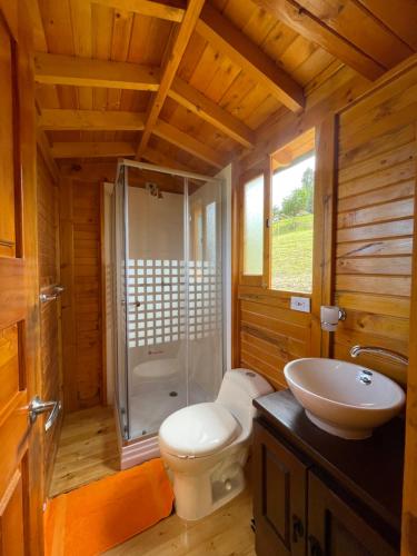 La salle de bains est pourvue de toilettes, d'une douche et d'un lavabo. dans l'établissement Glamping y Chalet Aventura Park Villa De Leyva La Periquera, à Villa de Leyva