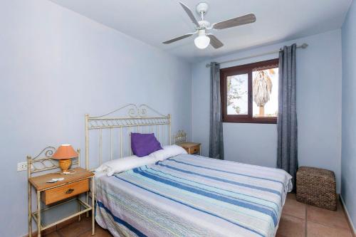 1 dormitorio con 1 cama y ventilador de techo en Harmony House, Golf del Sur, en San Miguel de Abona