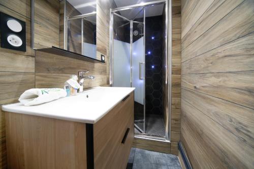 La salle de bains est pourvue d'un lavabo et d'une douche. dans l'établissement #La Tardière#, à Clermont-Ferrand