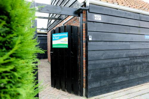 a black fence with a sign on it next to a building at Morning Glory in Wemeldinge