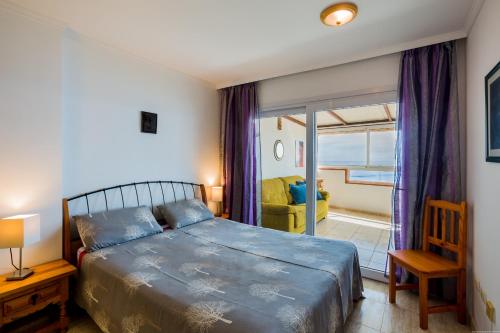 a bedroom with a bed and a chair and a window at Apartment Ceyla Beach View, Los Cristianos in Los Cristianos