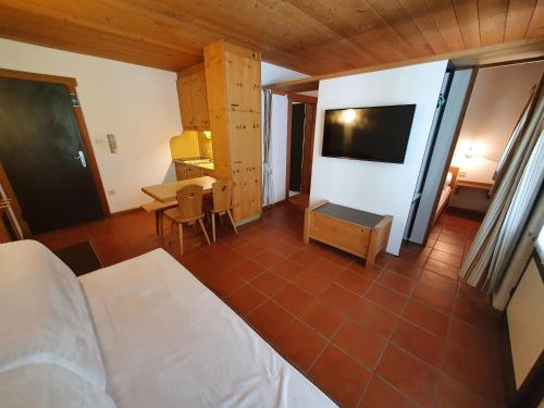 a bedroom with a bed and a desk and a television at Residence Silvester in Racines