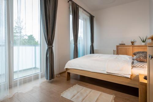 a bedroom with a bed and a large window at Apartment PEAK - Apartmany Bernard Stary Smokovec in Vysoke Tatry - Novy Smokovec