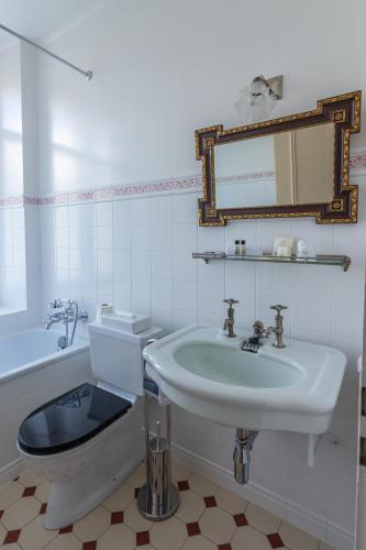 a bathroom with a sink and a toilet and a mirror at Grand Hôtel des Rasses & Wellness in Les Rasses