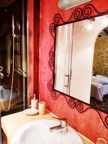 une salle de bain avec un lavabo et un miroir dans l'établissement Chambre d'hôtes face au lavoir, à Méthamis