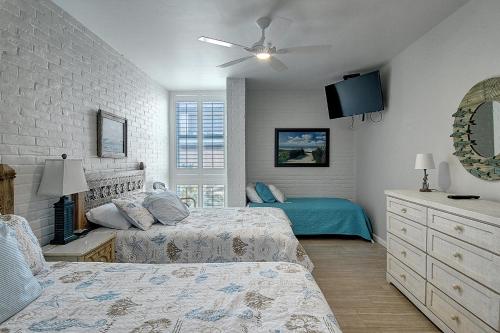 a bedroom with two beds and a ceiling fan at Channelview 206 in Port Aransas