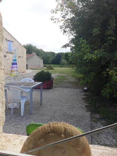 a patio with a table and chairs and a table at La maison neuve in Fontaines