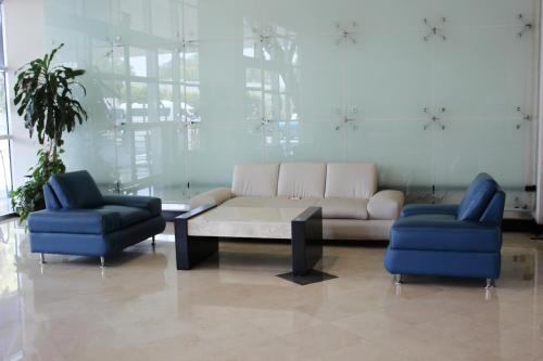 a living room with a couch and two blue chairs at Crowne Plaza Leon by IHG in León