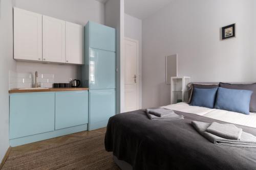 a bedroom with a large bed with blue cabinets at Delis Apartments - Dluga Street 11/3 in Krakow