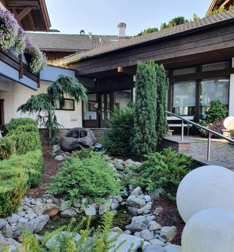 a garden in front of a house with a creek at Residence Silvester in Racines