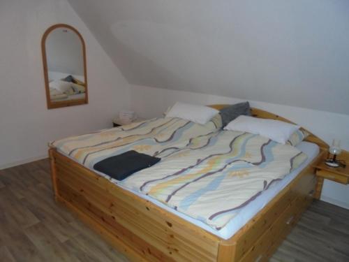 ein Bett mit einem Holzrahmen in einem Zimmer in der Unterkunft Ferienwohnung Küper in Getelo