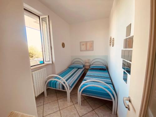 2 camas individuales en una habitación con ventana en Brezza di Mare en Torre Canne