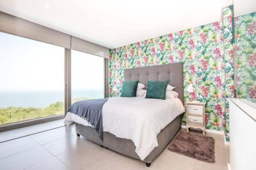 Schlafzimmer mit einem Bett und einer Fensterwand in der Unterkunft Ocean Dune Luxury Apartment 411 in Umhlanga