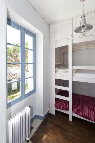 une chambre avec deux lits superposés et une fenêtre dans l'établissement 350m de la mer - maison pour 6, à L'Ile d'Yeu