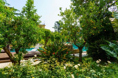 a garden with trees and flowers in front of a building at Villa Manning Relais in Sorrento
