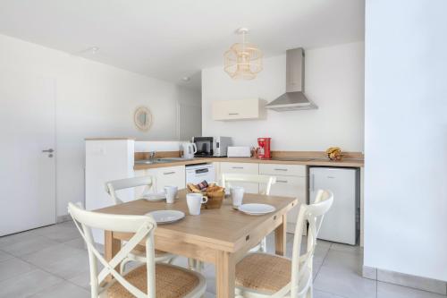 une cuisine avec une table et des chaises en bois dans l'établissement Bel appartement pour 4 - Balcon - 50m de la plage, à Pléneuf-Val-André