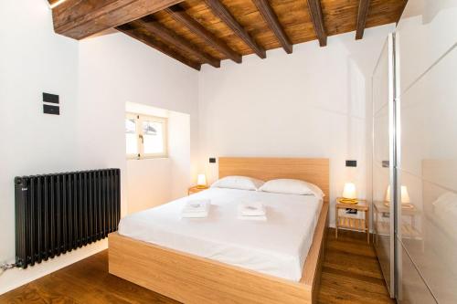 Schlafzimmer mit einem weißen Bett und einer Glasdusche in der Unterkunft Stylish Quardilatero Romano Central Flat in Turin