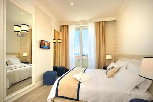 a hotel room with a bed and a large mirror at Grand Hotel & Riviera in Lido di Camaiore