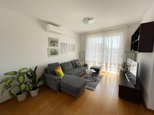 uma sala de estar com um sofá e uma janela em LIPA Apartment em Zagreb