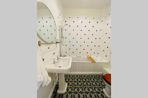 Baño blanco con lavabo y espejo en NomiHomes-Otis House-Free Parking x 2-Central -10ppl, en Exeter