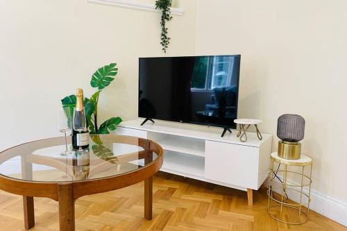 a living room with a tv and a coffee table at Nomi Homes - Otis House - Free Parking - Central -10ppl in Exeter