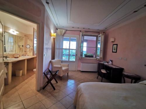 a bedroom with a bed and a desk and a bathroom at Il Melograno Country House in Saturnia