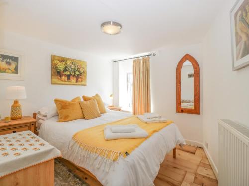 a bedroom with a large bed and a window at Mackerel Cottage in Budleigh Salterton
