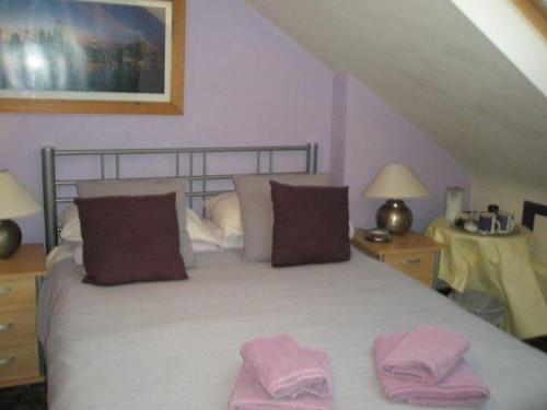 a bedroom with a bed with two pink towels on it at Kew Gardens National Archives Forest Road in London