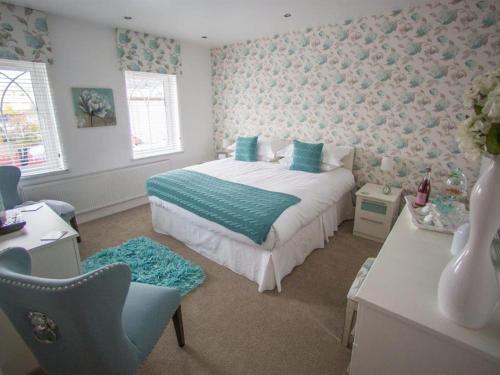 a bedroom with a bed and a desk with a chair at Queen Bee & B in Merthyr Tydfil