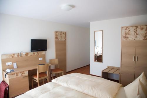 um quarto com uma cama, uma secretária e uma mesa em Gasthaus Merkel Hotel em Bad Berneck im Fichtelgebirge