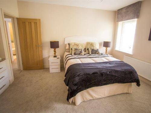 a bedroom with a large bed and a window at Queen Bee & B in Merthyr Tydfil