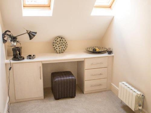 a room with a desk with a fan and windows at Queen Bee & B in Merthyr Tydfil
